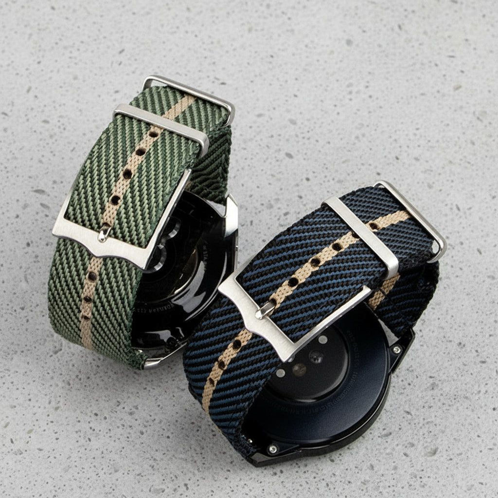 The bottom of two striped nylon watch straps, one green and beige, one blue and beige on watches
